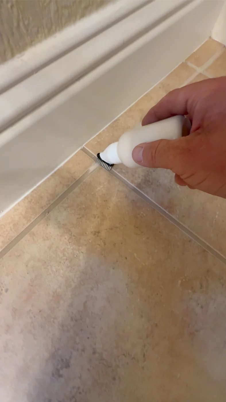 Close-up of light grout color being applied along a floor joint